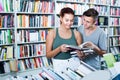 Two smiling teenagers reading book together Royalty Free Stock Photo