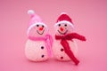 Two smiling toy christmas snowman on pink Royalty Free Stock Photo