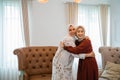 two smiling veiled Muslim women embracing each other