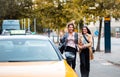 Smiling woman hurry to the taxi