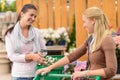 Two smiling woman shopping plants garden center Royalty Free Stock Photo