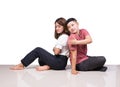 Two smiling woman young girls and happiness tomboy friends sitting on tile floor with white background Royalty Free Stock Photo