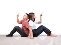 Two smiling woman young girls and happiness tomboy sitting on tile floor finger point above with white background Royalty Free Stock Photo