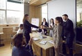 Two happy business teams meeting in the office, making a deal and exchanging handshakes Royalty Free Stock Photo