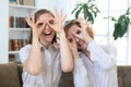 Two smiling women showing positive face emotions while siiting on sofa