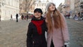 Two smiling women sisters tourists walking together on city street, young couple talking, embracing Royalty Free Stock Photo