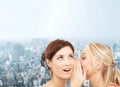 Two smiling women whispering gossip Royalty Free Stock Photo