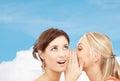 Two smiling women whispering gossip Royalty Free Stock Photo