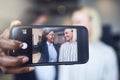 Two smiling young businesswoman using a cellphone to take selfie