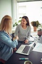 Two smiling businesswomen shaking hands together in an office Royalty Free Stock Photo