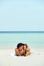 Two suntanning friends looking at cellphone photos on a beach Royalty Free Stock Photo