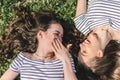 Two smiling young female girl friends having fun in park. Trendy Hipster Best friends Girls Relaxing on the Grass . Summer