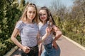 Two smiling young female girl friends having fun in park. Two teen student young woman in jeans Royalty Free Stock Photo