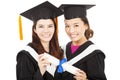 Two smiling young graduate students holding a diploma Royalty Free Stock Photo