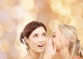 Two smiling young women whispering gossip Royalty Free Stock Photo
