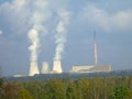 Two smoking chimneys of a power plant in the background behind the forest, as well as a tall chimney, do not smoke Royalty Free Stock Photo