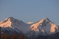 Two snow-capped peaks of the Trans-Ili Alatau mountains, painted orange by the morning rising sun