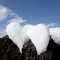 Two snow hearts on rock