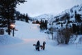 Two snowboarders leave the slopes after their last run