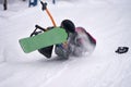 Two snowboarders lost their balance on a rope lift. They fell, but they do not let go of the rope in violation of safety requireme