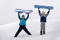 Two snowboarders raised arms standing Royalty Free Stock Photo