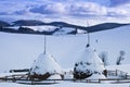 Two snowed haystacks