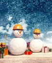 Two Snowman workers with presents at Christmas night