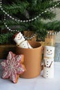Two snowmans of marshmallow near by the mug in Christmas time