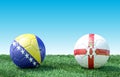 Two soccer balls in flags colors on green grass. Bosnia and Herzegovina and Northern Ireland Royalty Free Stock Photo