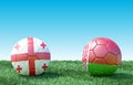 Two soccer balls in flags colors on green grass. Georgia and Belarus.