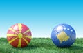 Two soccer balls in flags colors on green grass. North Macedonia and Kosovo.