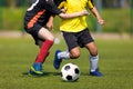 Two soccer players running and kicking a soccer ball. Legs of two young multiracial football players on a match Royalty Free Stock Photo