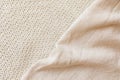 Two soft beige knitted blankets lying diagonally with copy space