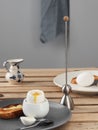 Two soft-boiled eggs, white eggs on a wooden brown table. Gray ceramic plate with soft-boiled egg, fried toast with butter. Royalty Free Stock Photo