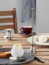 Two soft-boiled eggs, white eggs on a wooden brown table. Gray ceramic plate with soft-boiled egg, fried toast with butter. A cup Royalty Free Stock Photo