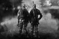 Two soldiers of a special unit are standing in a smoky forest. Royalty Free Stock Photo