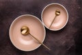 Two soup bowls and spoons on old dark brown table with scuffs. View from above. Dishes and utensils for serving and eating meals. Royalty Free Stock Photo