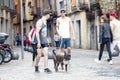 Two spanish cool guys in shorts with dogs, boxers on leashes