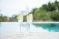 Two sparkling champagne glasses or prosecco near swimming pool. Summer travel, vacation, holiday and weekend concept Royalty Free Stock Photo