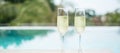 Two sparkling champagne glasses or prosecco near swimming pool. Summer travel, vacation, holiday and weekend concept Royalty Free Stock Photo