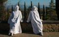 Two spooky white ghost with black eyes sitting in the wall of Castiglion Fibocchi. Halloween or carnival costume