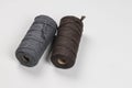 Two spools of cotton ropes of different colors.