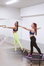 two sports girls are engaged in jumping on sports trampoline