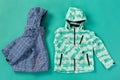 Two sports ski jackets, funny laying out, on a turquoise background, concept