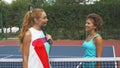 Two girls greeting on a tennis court Royalty Free Stock Photo