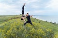 Two sportsmen practicing acro yoga together outdoors in the evening. Balancing girl legs up. Perfect flexibility. Athlete standing