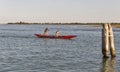 Two sportsmen rowing a gondola in Venice lagoon, Italy.