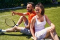 Two sportspeople sitting on the tennis court