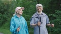 Elder european couple trekking poles walk nature forest park. Old people workout