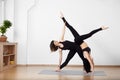 Two sporty smiling women doing yoga exercise and performing with Extended triangle pose and Handstand pose. Copy space